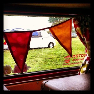 Rainy view from the back window of a split screen camper van